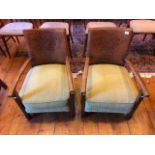 A pair of early 20th century leather back arm chairs, heraldic shield detail to backs, upholstered