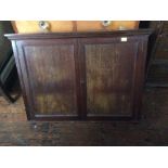 An Edwardian mahogany two door wall cabinet, the two panelled doors opening to reveal three shelves,