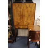 A mid 20th Century flame mahogany veneered cocktail cabinet, with two doors and a drawer