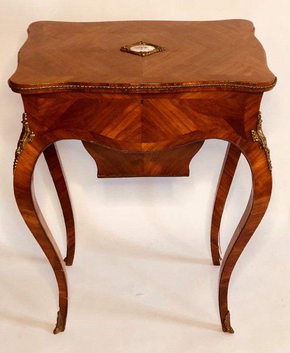 A Louis XV style kingwood and gilt bijouterie table, serpentine hinged top with a porcelain plaque