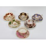 A group of early nineteenth century hand-painted porcelain cups and saucers, circa 1820-40. They are