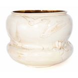 A large waisted Bretby Art Pottery moulded ivory ground jardiniere with moulded decoration of