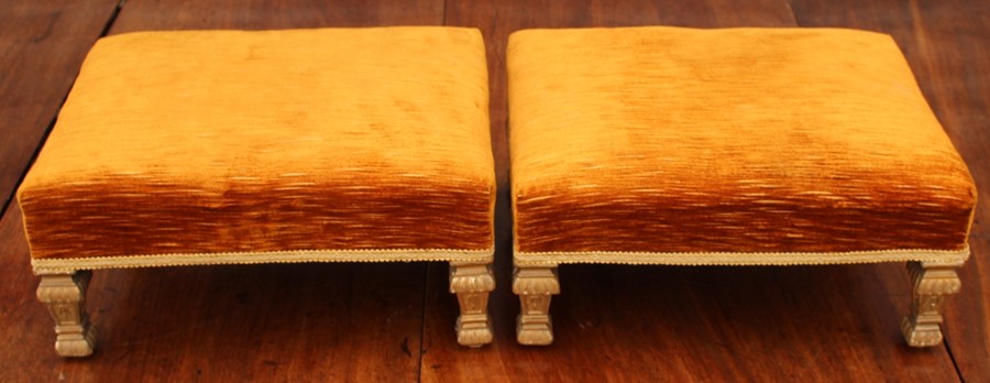 A pair of early 19th Century giltwood footstools, in the French taste, gold upholstery, raised on