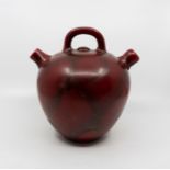 A Bretby art pottery sang de boeuf glaze double-spout flagon , No. 1997 E. 26 cm tall. (1)