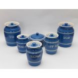 A group of Bretby art pottery food storage jars and covers with blue glazed and white banded
