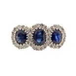 A sapphire and diamond 18ct yellow gold cluster ring, comprising three oval cut sapphires, each