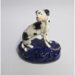 A Staffordshire model of a Hound sitting on a cobalt blue base with a gilt collar and chain Date: