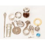 A collection of assorted silverware comprising: three napkin rings, miniature hand mirror, babies