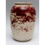 A large Ruskin high fired baluster vase, bloomed red flambe glaze over a white body, impressed