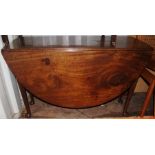 A George III mahogany drop leaf dining table, having two leaves, raised on off-centre turned legs,