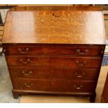 A George III oak bureau, circa 1770, the fall front opening to reveal a fitted interior comprising