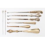 A collection of assorted button hooks, shoe horns, hat pins, etc with silver handles, Victorian