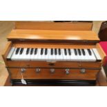 An early 20th Century Harmonium, fitted in a wood grained case, having three octaves, 26cm high,