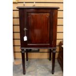 An Edwardian mahogany single door pot cupboard, the door enclosing a single shelf, raised on