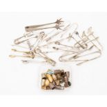 A quantity of EPNS sugar tongs, together with a good quantity of base metal etc thimbles