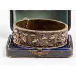 A Chinese white metal bangle, with embossed decoration featuring sea creatures, width approx.