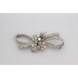 A diamond and platinum stylised brooch, set with round brilliant-cut and baguette cut diamonds,