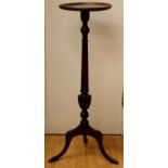 A George III style mahogany torchere, of recent manufacture. the circular top raised on a turned