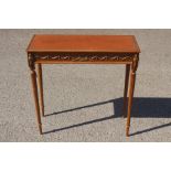 A Neo Classical style pale mahogany side table, leather inset top, the frieze applied with gilt