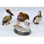 Four Royal Crown Derby paperweights in the form of a pelican, cock, swan and a puffin, gold stoppers