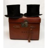 An early 20th Century tan leather double top hat box, containing two black silk Woodrow top hats