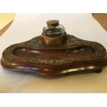 An early 20th century walnut desk stand with capstan style glass inkwell and pen well with applied