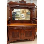 A late Victorian walnut mirror backed sideboard, the top with a carved pediment and moulded cornice,