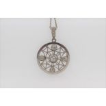 An Edwardian diamond and platinum circular brooch / pendant, set with five old-cut diamonds in a