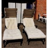 Two contemporary sun lounge recliners, with cream buttoned upholstery, with wheels and shades to
