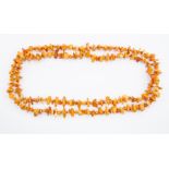 A single row Amber necklace, the rough polished long necklace comprising butterscotch and various