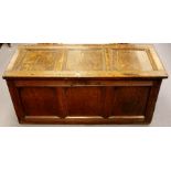 A late 17th or early 18th Century oak chest, three panelled lid, panelled front, panelled sides,