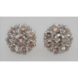 A pair of diamond cluster earrings, each with eight round brilliant-cut diamonds, total diamond