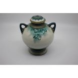 A Hadley's Worcester F125/4 Faience amphora shaped vase and cover, decorated with trailing green