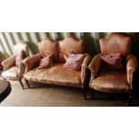 An Edwardian three piece suite, comprising a shield back two seater settee and two armchairs, pink