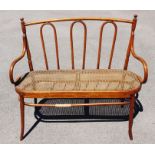 A Bentwood canework seated two seater settle, made from steam-bent beechwood, having a hoop design