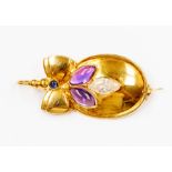 An 18ct gold stone set brooch, oval form set with cabochon purple stones with a central marquise cut