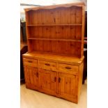 A 20th Century traditionally made pine dresser and rack, the rack with two plate shelves, the base