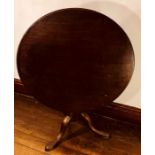 A George III mahogany tilt top table, circa 1800, circular top above a turned column on tripod