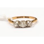 A diamond three stone 18ct gold ring, comprising three old cushion cut diamonds claw set in