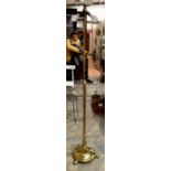 A 19th Century brass standard lamp, hand hammered base, raised on three feet