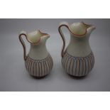 A pair of graduated Regency jugs, marked WW, baluster shaped with lower fluted sections piqued in