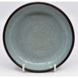 An interesting Chinese green celadon dish with bronzed painted rim, various marks, 14 cms diameter