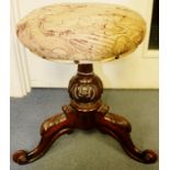 An early Victorian rosewood piano stool, having a revolving circular seat, raised on a turned