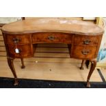 A George V walnut kidney shaped desk, fitted with one long drawer and four small drawers, cabriole