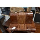 A mid 20th Century brown crocodile skin hand bag, plus a matching writing case, bought in 1949
