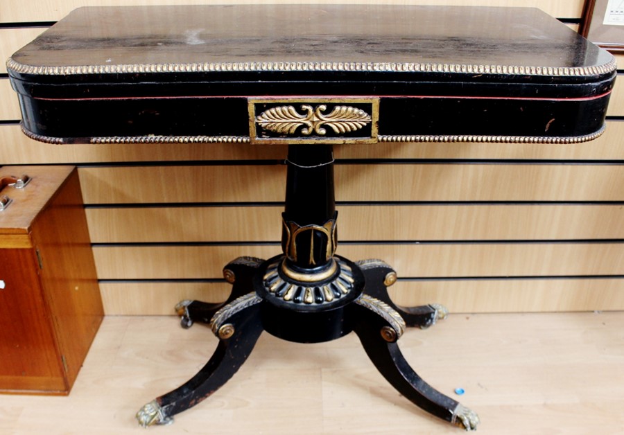 A late 19th Century ebonised gilt card-table, the hinged top revolving for support on a turned
