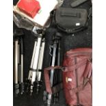 A collection of photographic equipment including tripods, vintage and modern cameras, lenses etc
