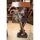 Circa late 19th Century cast iron stick stand with 20th Century walking sticks, Empire style