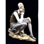 A Lladro 'Don Quixote Dreaming', depicting a man sitting, no. 2084, marked to underside. Height