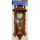 A 19th Century walnut Vienna wall clock, having a double weighted eight day movement, the finial